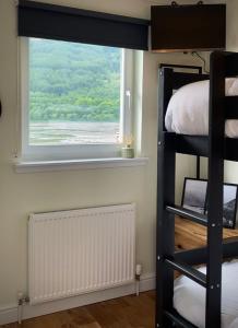 ein Schlafzimmer mit einem Etagenbett und einem Fenster in der Unterkunft Lochside Guest House in Arrochar