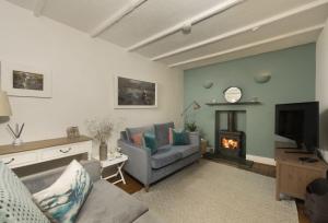 a living room with a couch and a fireplace at Cob Cottage in St. Agnes