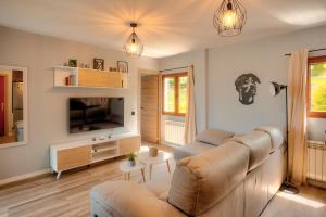 a living room with a couch and a television at El mirador de Mogro in Mogro