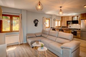 a living room with a couch and a kitchen at El mirador de Mogro in Mogro