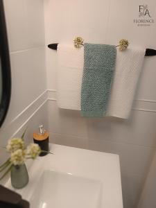 a bathroom with three towels on a sink at Florence apartman Hajdúszoboszló in Hajdúszoboszló +5 photos