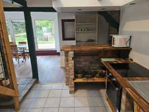 a kitchen with a stone fireplace in a room at Ferienhaus Banana Lodge in Bruchhausen-Vilsen