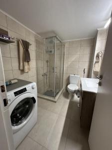 a bathroom with a washing machine and a toilet at Piraeus Seaside Apartment Escape in Piraeus +33 photos