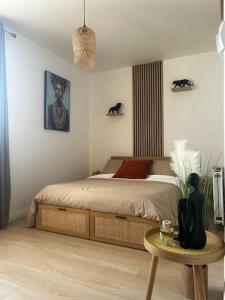 a bedroom with a bed and a table in it at Appartement La Perle Urbaine in Bourges +23 photos