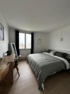 a bedroom with a bed and a desk and a window at Appartement La Perle Urbaine in Bourges