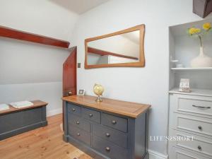 een slaapkamer met een dressoir en een spiegel aan de muur bij Bury Meadow Lodge - Exeter - Train 5 min walk - Parking in Exeter