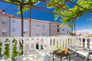 a balcony with a white fence and a table at Mirna Luka in Punat