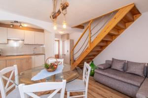 a kitchen and living room with a glass table and a staircase at Mirna Luka in Punat
