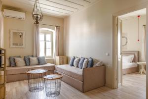 a living room with a couch and two tables at Teacher's House in Meganisi