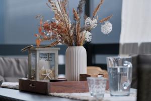a table with a vase with flowers and a lantern at Mobile Home Ella in Sveti Petar