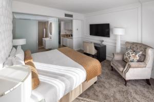 a bedroom with a bed and a chair and a television at Pepperclub Hotel in Cape Town
