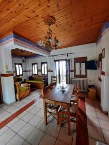 a living room with a wooden ceiling and a table at Milea Byron House Tsagarada in Tsagarada