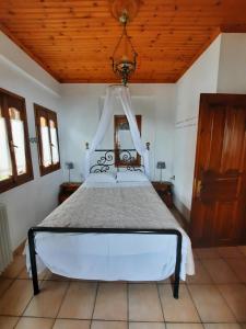a bedroom with a bed with a wooden ceiling at Milea Byron House Tsagarada in Tsagarada