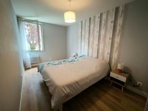 Un dormitorio con una cama blanca y una ventana. en Appartement F3 Centre-Ville, en Gonesse