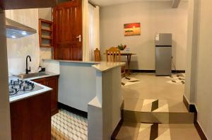 a kitchen with a sink and a refrigerator at Peakline Apartments in Arusha +49 photos