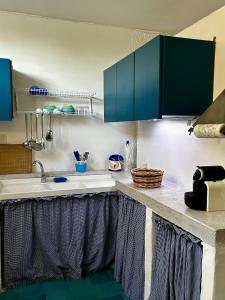 a kitchen with blue cabinets and a sink at Capitolo in Monopoli
