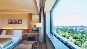 a hotel room with a bed and a large window at Millennium Hotel Chengdu in Chengdu