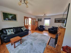 un soggiorno con un divano e un tavolo di Ocean Breeze Cottage a Caherdaniel