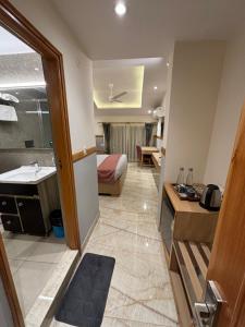 a hotel room with a bathroom with a bed and a sink at The Cocoon in Dehradun