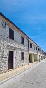 a stone building with two garage doors on a street at Civico134 in Sirolo