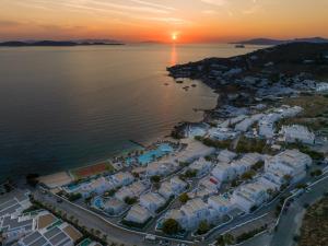 an aerial view of a resort on the water at sunset at Saint John Hotel Villas & Spa in Agios Ioannis Mykonos +61 photos