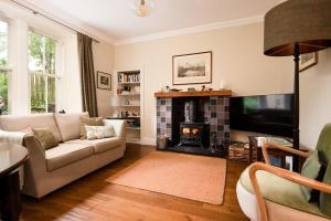 a living room with a couch and a fireplace at Pentland Cottage in Norham