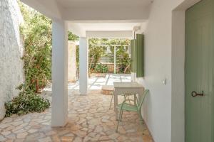a patio with a table and a chair next to a door at Teacher's House in Meganisi
