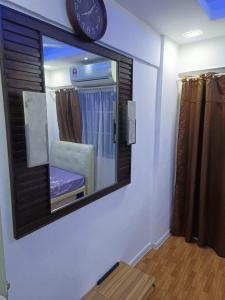 un espejo en una pared con un reloj en ella en Teluk Air Tawar Home, en Butterworth