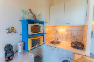 Una pequeña cocina con fregadero y microondas. en Sanary Bandol plein SUD, en Sanary-sur-Mer