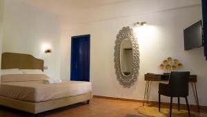 a bedroom with a bed and a mirror and a desk at Boutique San Daniele B&B in Cirella