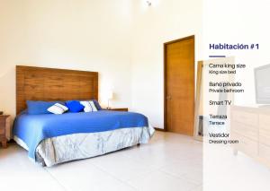 - une chambre avec un lit doté de draps bleus et d'une tête de lit en bois dans l'établissement Casa Hacienda La Herradura Zapopan, à Santa Cruz del Astillero