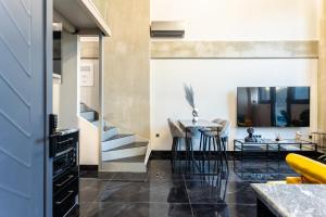 a living room with a staircase and a table at Ventiri Lofts - Kalamata Luxury Penthouses in Faraí