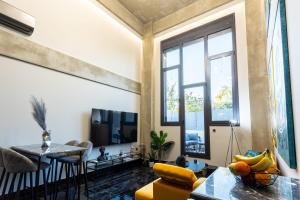 a living room with a yellow chair and a tv at Ventiri Lofts - Kalamata Luxury Penthouses in Faraí +124 photos