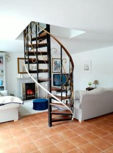 a spiral staircase in a living room with a fireplace at Cozy seaside cottage in Wexford