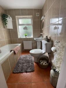 a bathroom with a toilet and a tub and a sink at Cozy seaside cottage in Wexford +37 photos