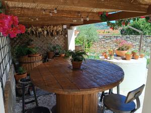 a wooden table in a patio with potted plants at A Casa dos Retales in Cangas de Morrazo