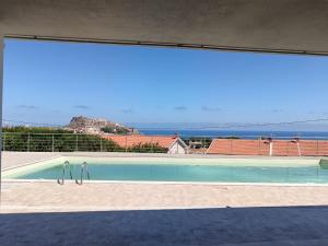 a swimming pool with a view of the ocean at Appartamento Il Tramonto in Castelsardo