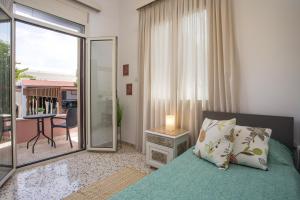 une chambre avec un lit et une vue sur un balcon dans l'établissement Thelia Rhodian Traditional house, à Rhodes