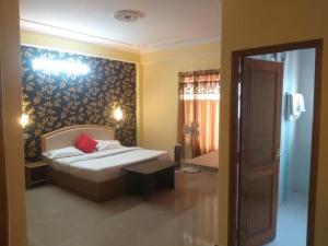 a bedroom with a bed with a red pillow at Prestige Villa in Shimla