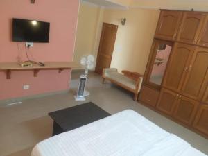 a room with a bedroom with a bed and a tv at Prestige Villa in Shimla