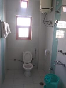 a small bathroom with a toilet and a window at Prestige Villa in Shimla +10 photos