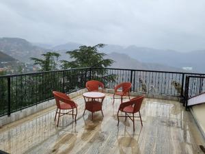a patio with chairs and a table on a balcony at Prestige Villa in Shimla