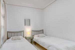 two beds in a room with white walls at Lux de Novamar en Gran Alacant in Puerto Marino