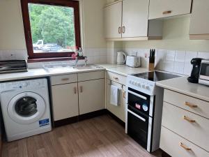 a kitchen with a washer and a sink and a dishwasher at Waverley Court in Fort William