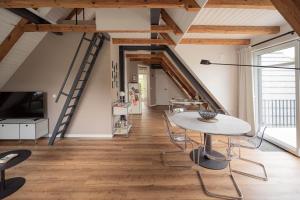 a room with a table and chairs and wooden ceilings at Traumhafte Ferienwohnung am Park, großer Balkon, voll ausgestattete Küche, Schreibtisch, WiFi, Smart TV, Carport, Wallbox, Fahrräder in Scheeßel