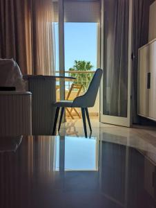 a chair and a table in a room with a balcony at Dar soufia in Nabeul