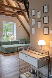 a living room with a couch and a table at Traumhafte Ferienwohnung am Park, großer Balkon, voll ausgestattete Küche, Schreibtisch, WiFi, Smart TV, Carport, Wallbox, Fahrräder in Scheeßel