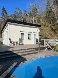 Der Schatten eines Mannes, der auf einer Terrasse neben einem Gebäude steht in der Unterkunft Pool House in Tyresö