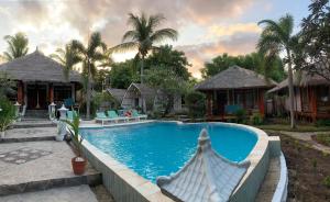 a swimming pool in front of a resort at Biba Beach Village in Gili Islands