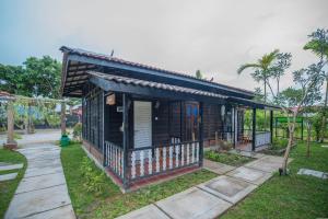 a small house with a porch in a park at The Daun Resort Langkawi in Pantai Cenang